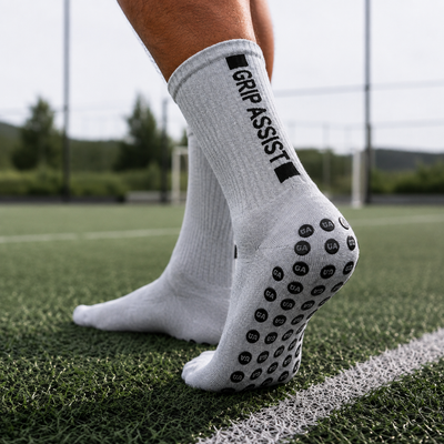 Grip socks grises Grip Assist X2 à pastilles antidérapantes, sur un terrain synthétique