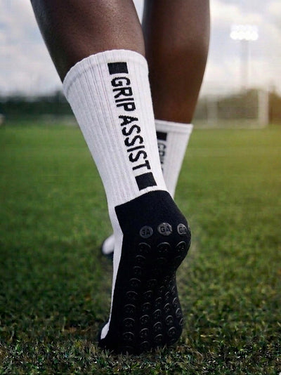 Grip socks blanches à semelle noire Grip Assist X2, portées sur un terrain de soccer